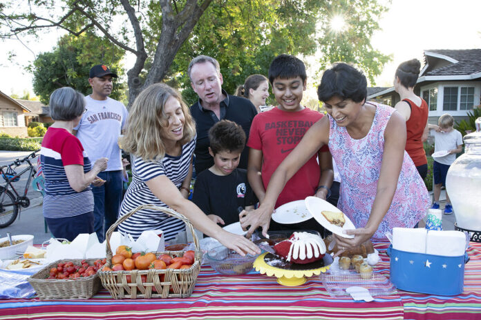 Megan V. Winslow/Town CrierAnna Iannacone, far left, helps Radha Kanekal, far right, serve Chris Iannacone, in black, and Ajay Lohitsa, in red, as David Head watches during an Aug. 16 Ben Roe Drive block party.