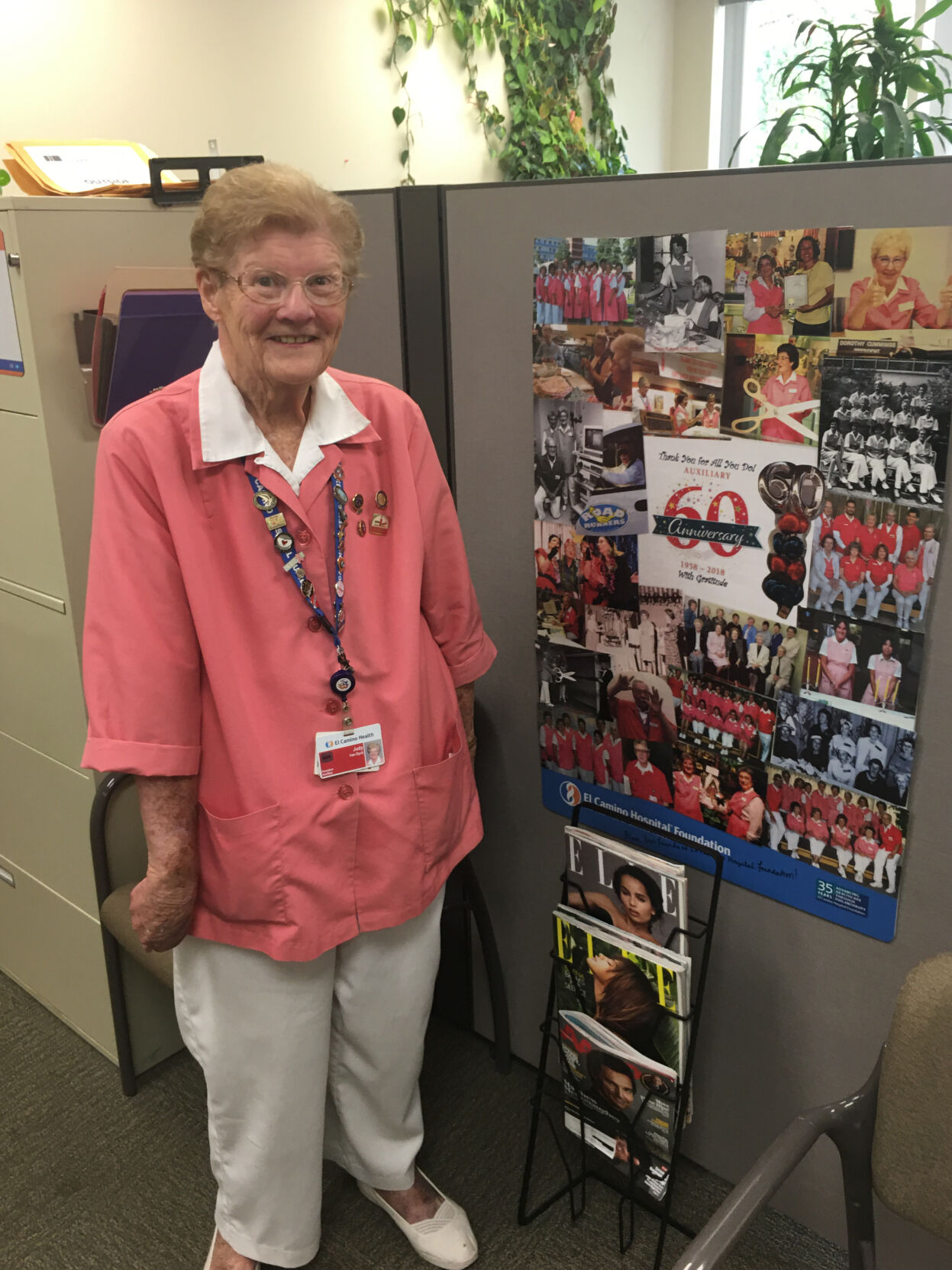 Judy Van Dyck stands by a collage of photos chronicling 60 years of support by the El Camino Hospital Auxiliary. The auxiliary’s founding predates the opening of the hospital, which is celebrating its 60th anniversary next week.