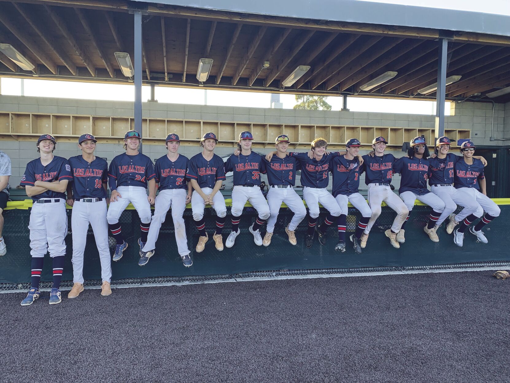 Members of Los Altos & Los Altos Hills Little League’s Senior Division sit together in the dugout after one of their playoff wins. The squad placed third in the West Region Tournament, which is the best any team from the local league has done in the postseason.