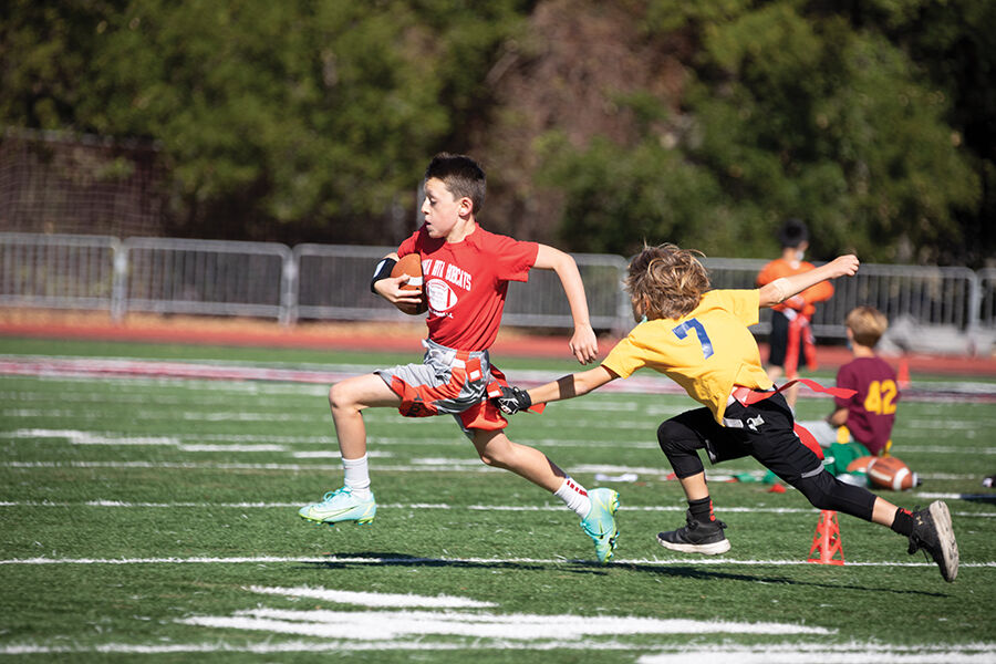 A player on the Santa Rita Elementary School third- and fourth-grade flag football team tries to evade a defender in the district championship game last fall.