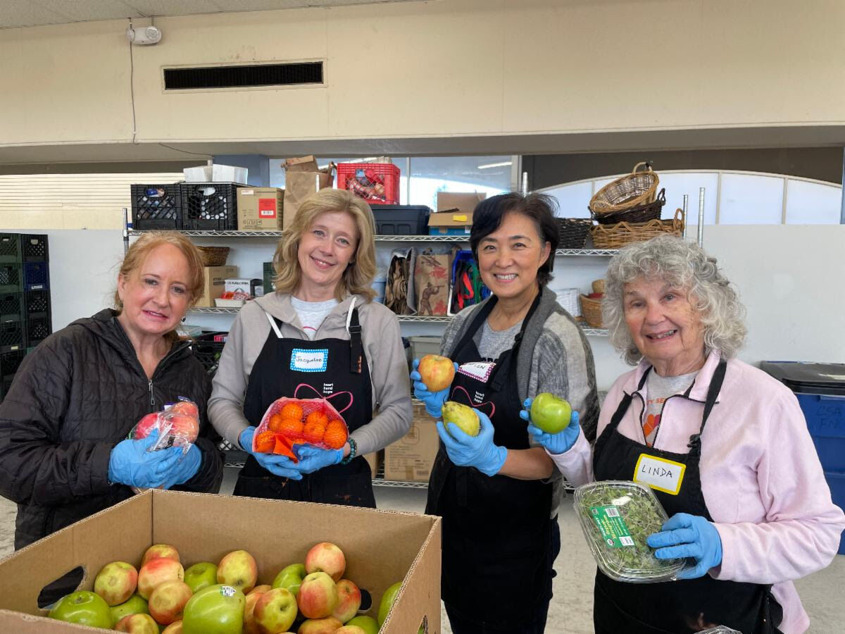 Volunteers at Community Service Agency’s food pantry sort produce.