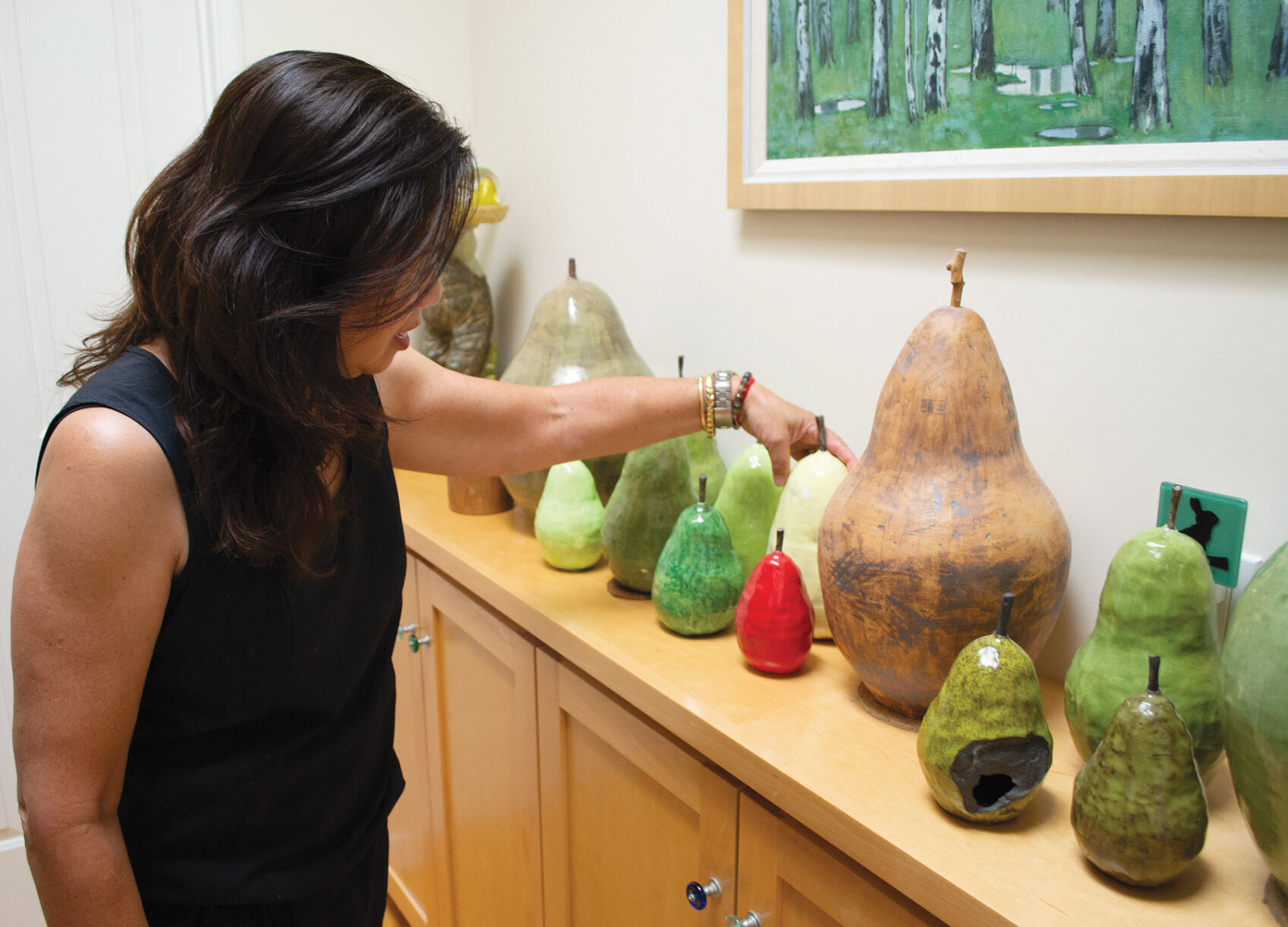 Los Altos resident Corrie Dunn displays her collection of “rotten” pears created by her sister, artist Rae Dunn.