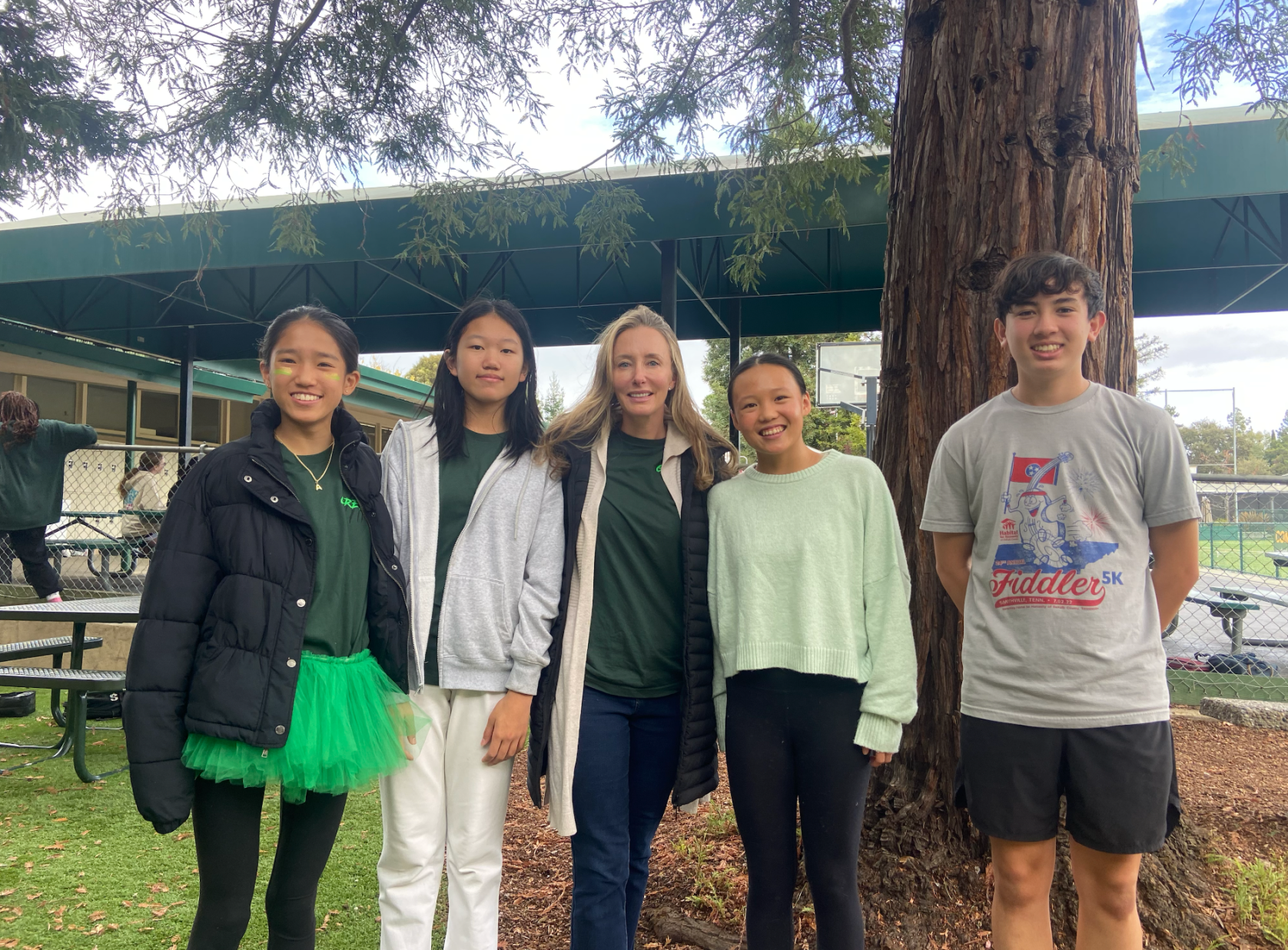 8th grade Pinewood School students left to right Adelynn Wang, Joyce Yan, Emma Hsieh and Brandon Armistead pose with their 7th grade writing class teacher Michelle Gannon (center). Gannon assigned her class last school year to record a podcast about their identity. The four students were honorable mentions in the 2024 Student NPR Podcast Challenge.