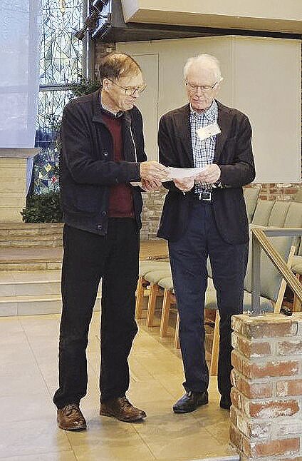 Ian Hodder confers with Morning Forum vice president John Miller about an audience question.