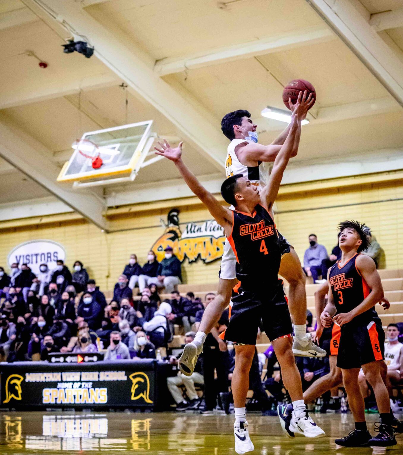 Mountain View High's Patrick Kane drives to the basket amid two Silver Creek defenders in Tuesday's playoff game.