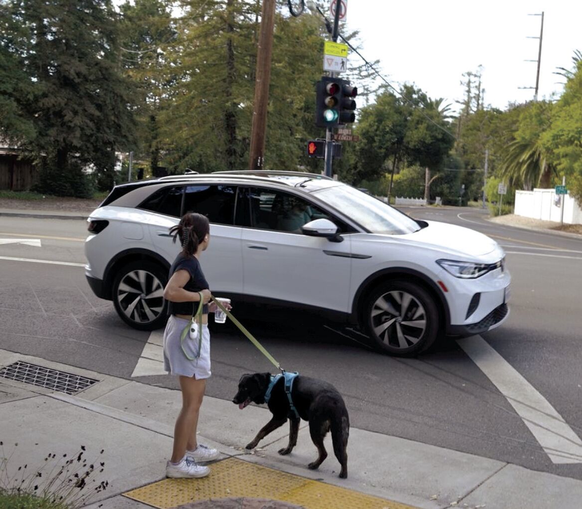 Crossing Edith Avenue, like the walker in the photo above, pedestrians confront vehicle traffic accelerating to merge onto Foothill Expressway. City officials plan to implement traffic-calming measures along Edith this fall, but any changes to the Foothill-Edith intersection will have to come under the direction of Santa Clara County.