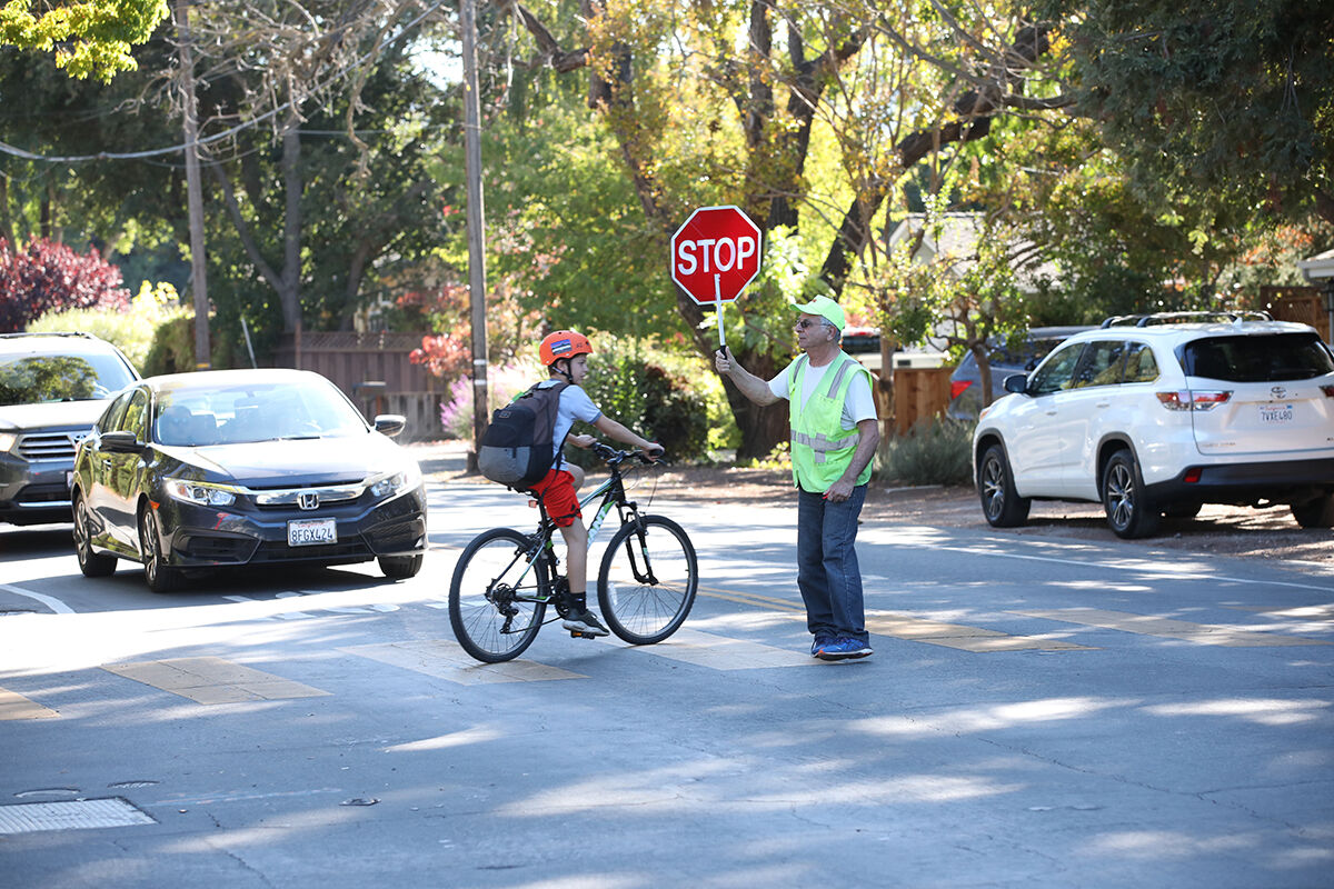 A crossing guard assists students at the corner of Covington Road and Miramonte Avenue in 2019.