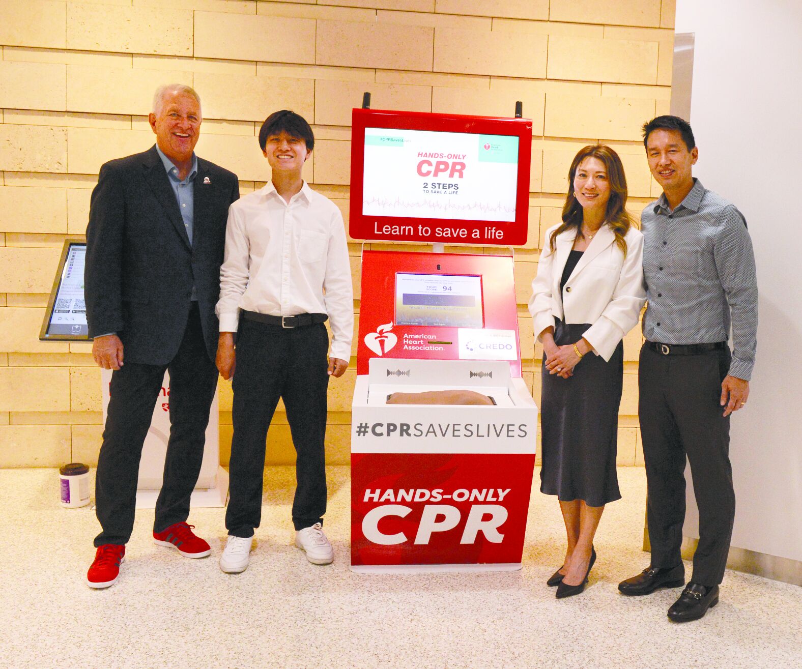 From left, Bill Brennan and the Chian family pose with the CPR kiosk.