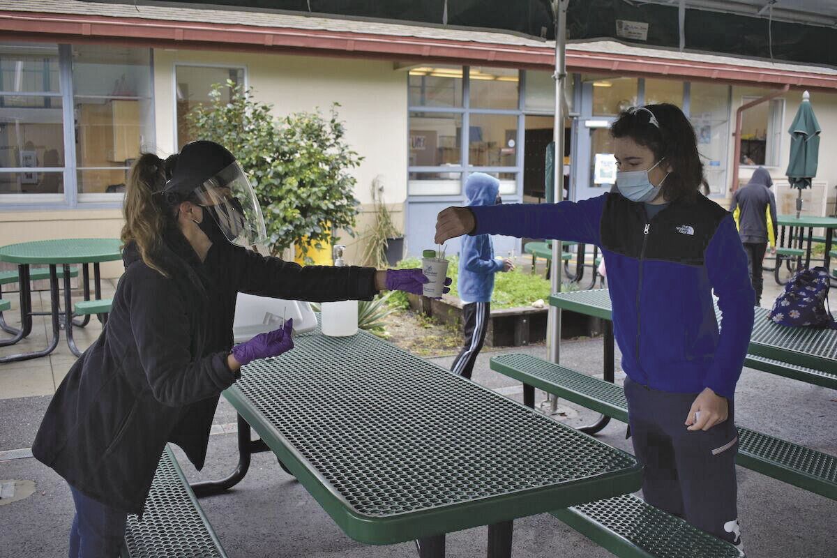 A Los Altos School District nurse collects a nasal swab from a student as a part of the pooled testing program in February 2021. According to the district, the need for health services work has gone down since the heigh of the pandemic.