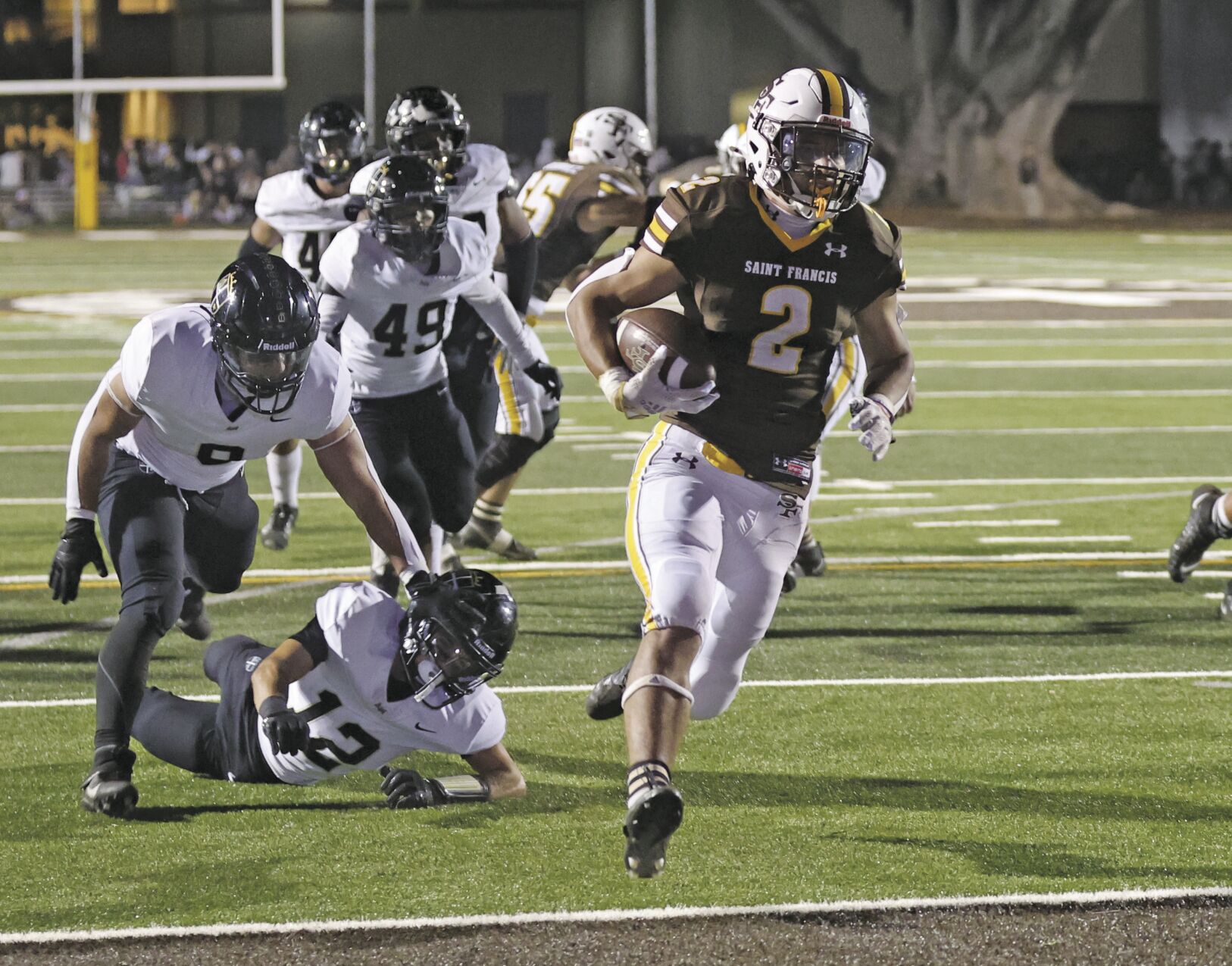 St. Francis running back Kingston Keanaaina runs past Mitty defenders to score a touchdown in Friday night’s home win for the Lancers.