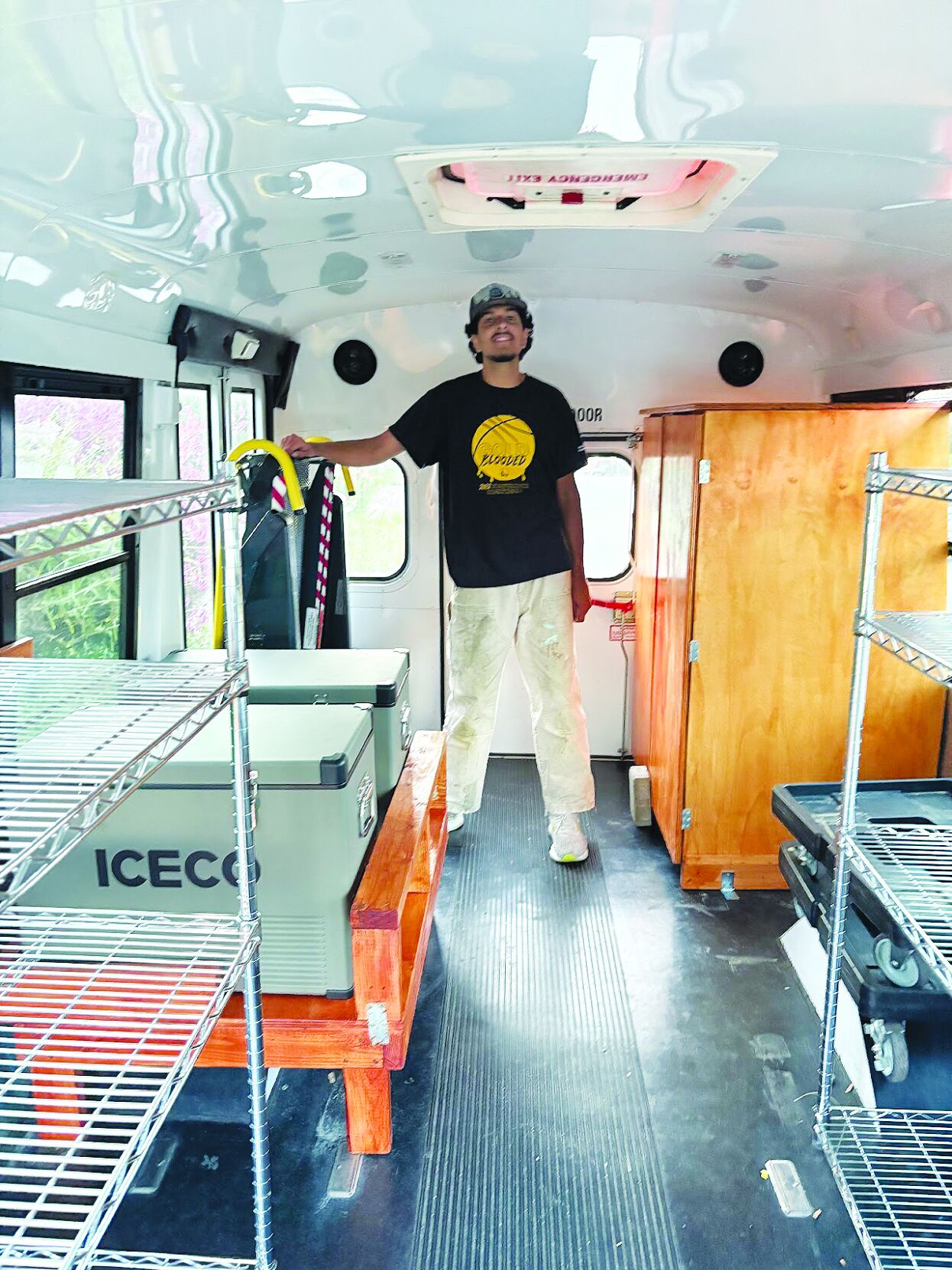 Sanay Jiandani stands in an old school bus he has converted into a mobile food pantry to bring accessible services to Martha’s Kitchen clients.